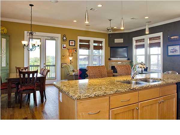 135 Sand Dunes Road Santa Rosa Beach, FL 32459 - Photo 9 of 19 a kitchen with kitchen island granite countertop a table chairs sink and wooden floor