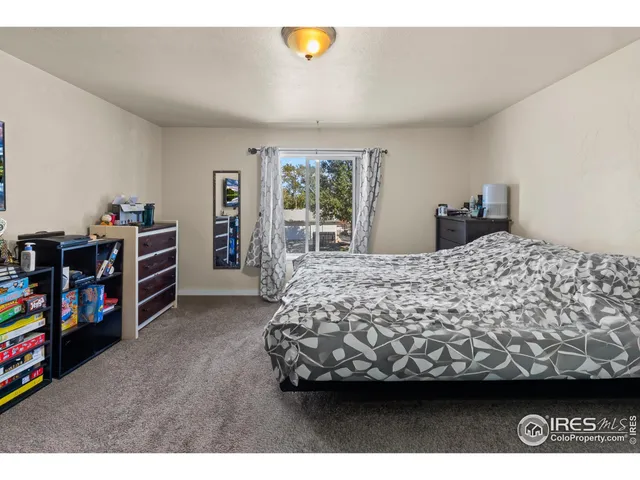 a bed sitting in a bedroom next to a window