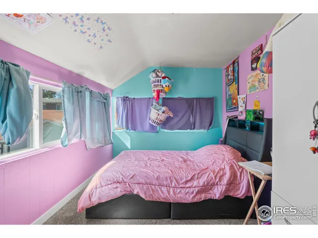 a bed room with a bed and a painting on the wall