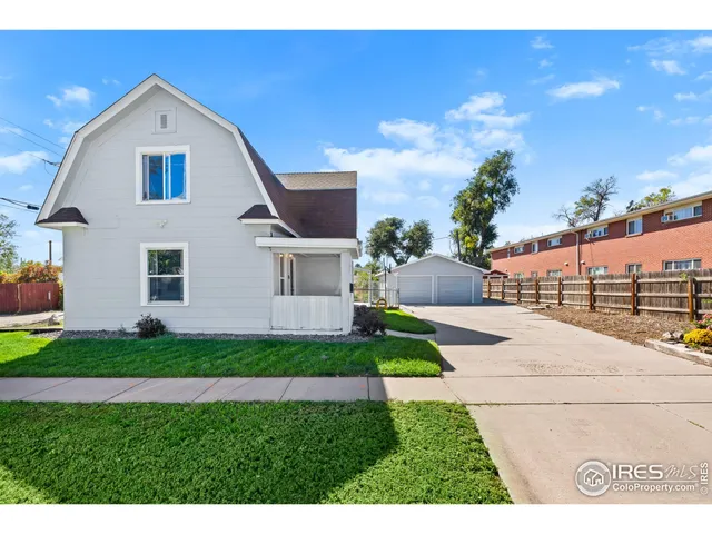 a front view of a house with a garden and yard