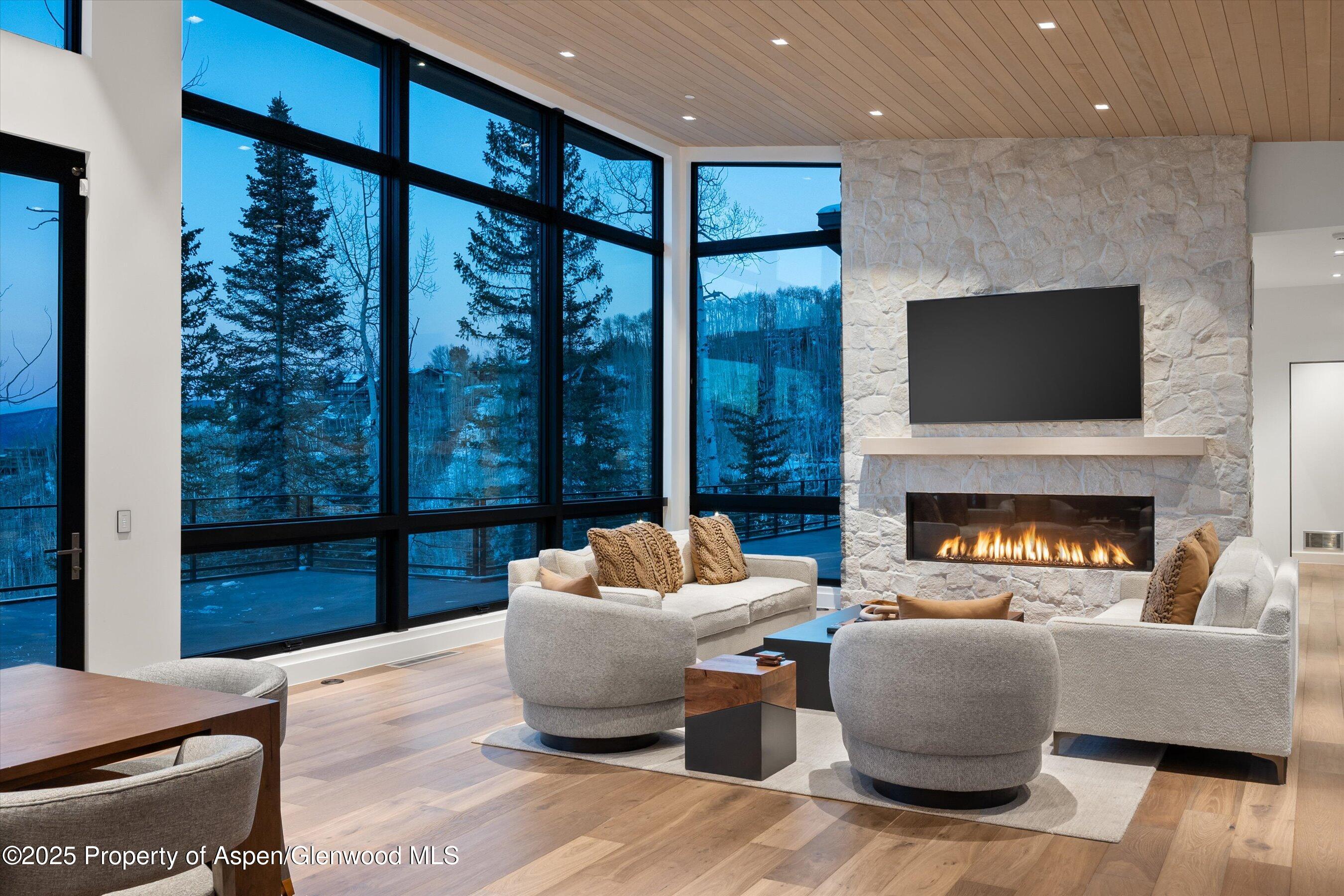 1234 Wood Road Snowmass Village, CO 81615 - Photo 64 of 66 a living room with furniture a fireplace and a flat screen tv