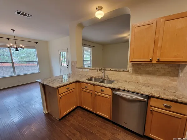 a kitchen with stainless steel appliances granite countertop wooden floors and sink