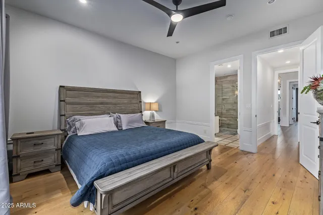 a bedroom with a large bed and ceiling fan
