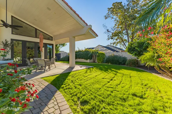 a view of a chairs and table in the back yard of the house