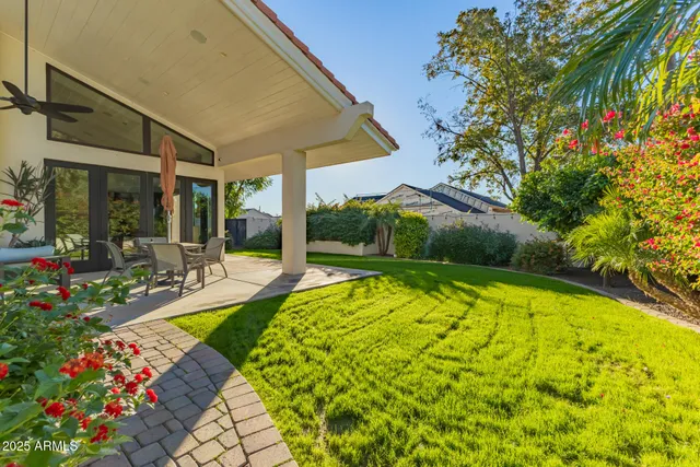 a view of a chairs and table in the back yard of the house