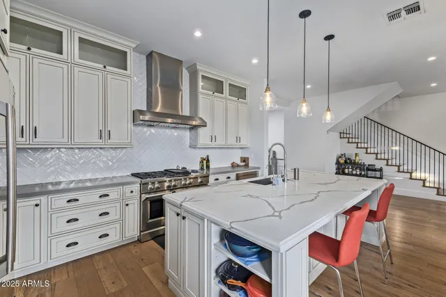 a kitchen with stainless steel appliances granite countertop a sink a stove and a refrigerator