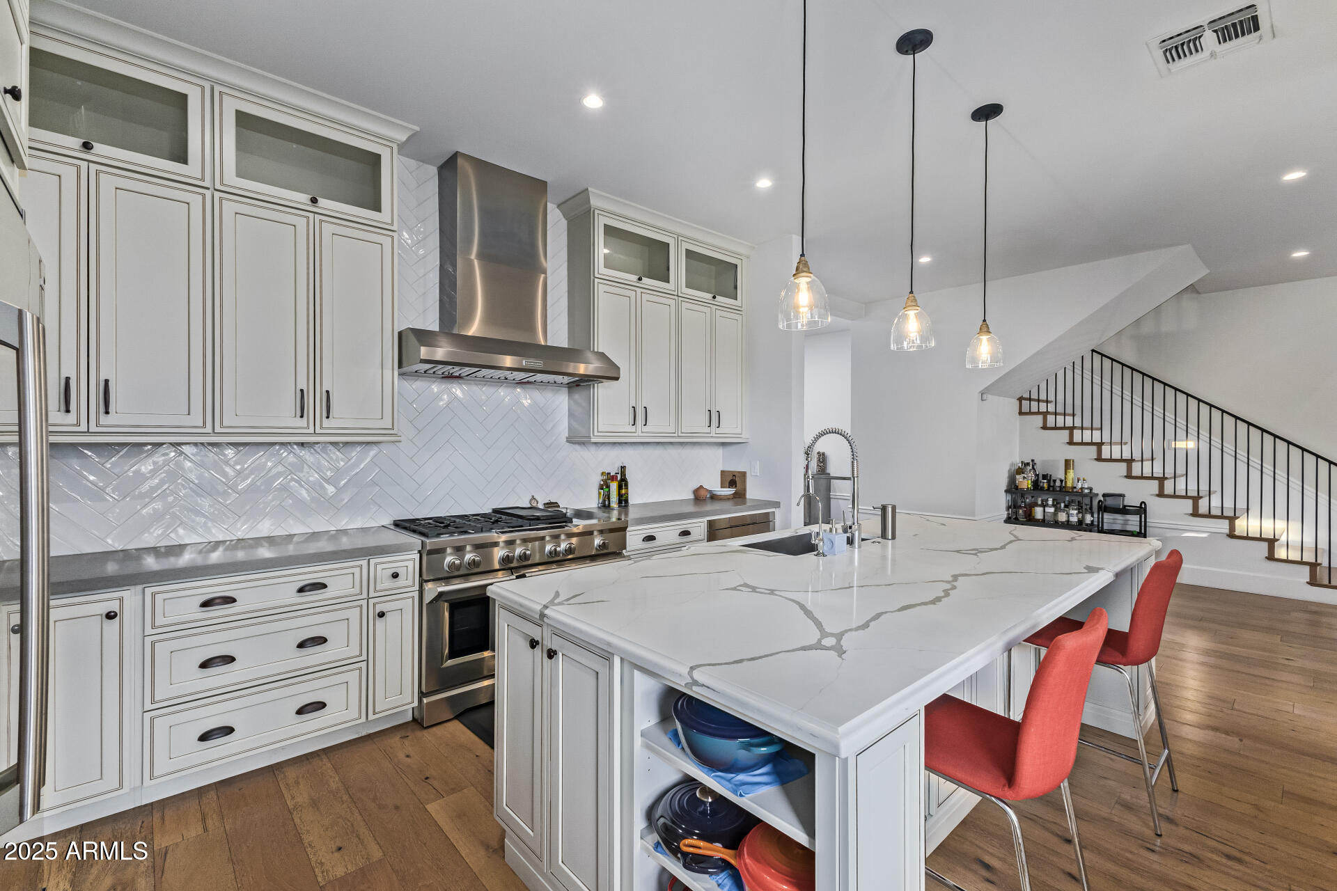 3810 East Campbell Avenue Phoenix, AZ 85018 - Photo 38 of 41 a kitchen with stainless steel appliances kitchen island granite countertop a stove a sink and white cabinets with wooden floor