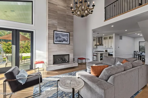 a living room with fireplace furniture and a large window