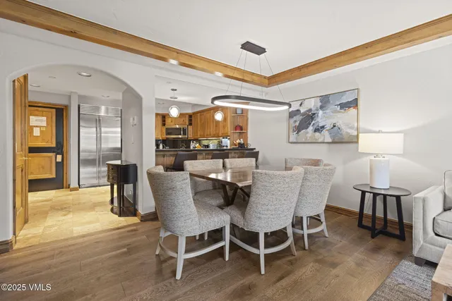 a living room with a couch a dining table and a large window with garden view