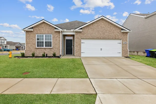 a front view of a house with a garden and yard