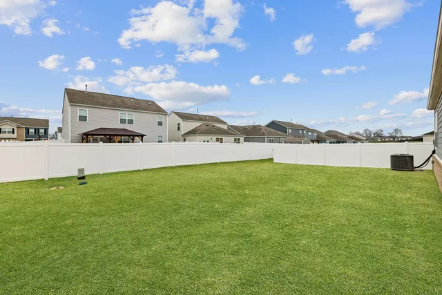a view of a house with a big yard and large trees