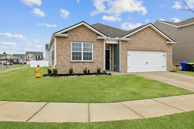 a front view of a house with a garden and yard