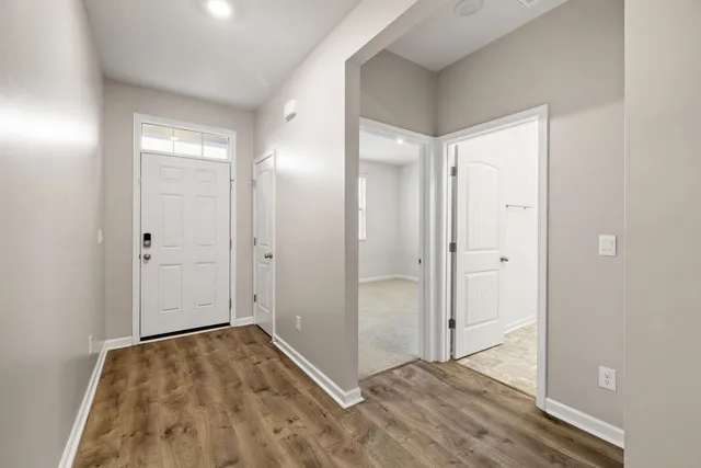 an empty room with wooden floor and mirror