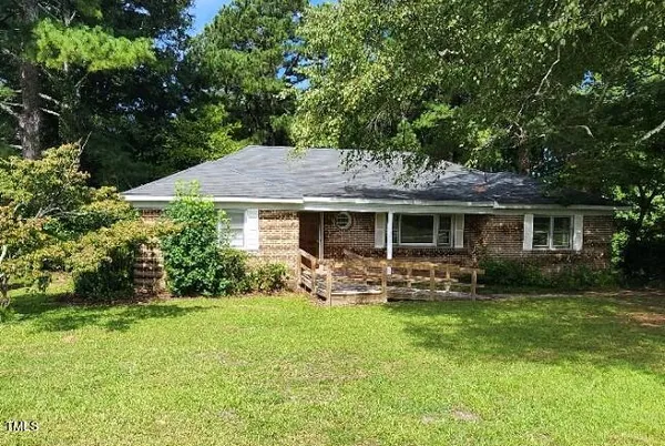 a backyard of a house with garden and outdoor seating
