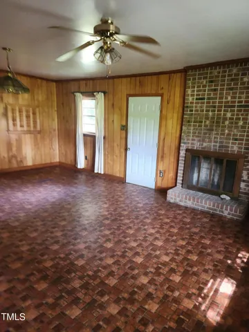 a view of an empty room with a fireplace and a window