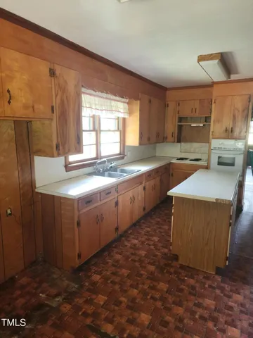 a kitchen with stainless steel appliances granite countertop a sink stove and cabinets