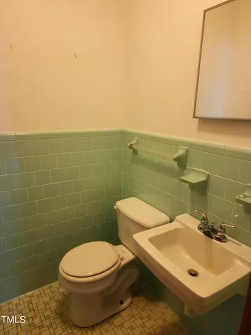 a bathroom with a sink a toilet and mirror