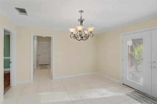 a bathroom with a chandelier fan and glass door