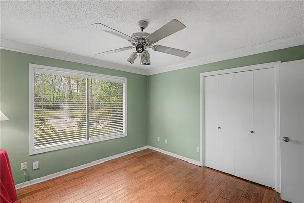 a view of an empty room with a window and wooden floor