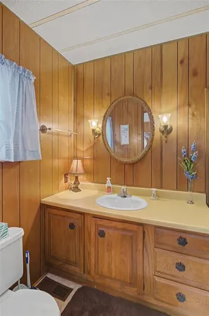 a bedroom with a bed and a dresser with mirror