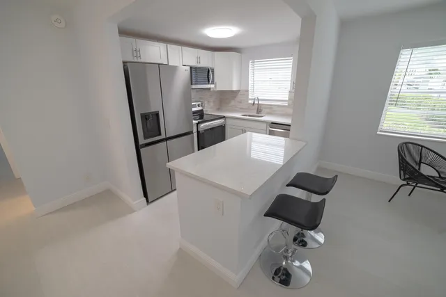 a kitchen with a refrigerator a sink and a cabinets