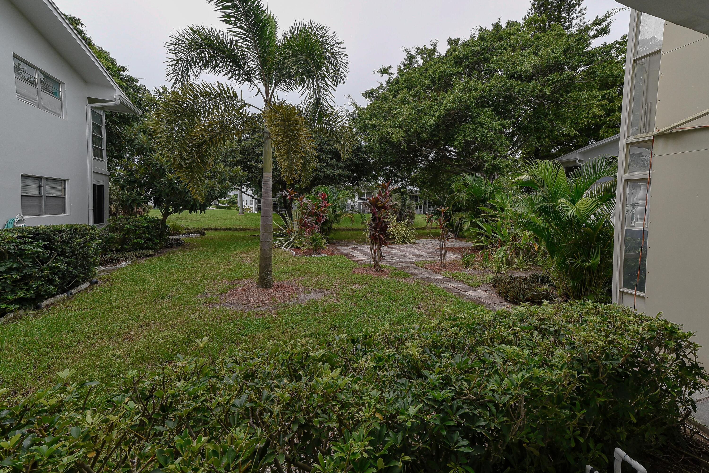 53 Lyndhurst East, Unit C Deerfield Beach, FL 33442 - Photo 19 of 23 a backyard of a house with lots of green space