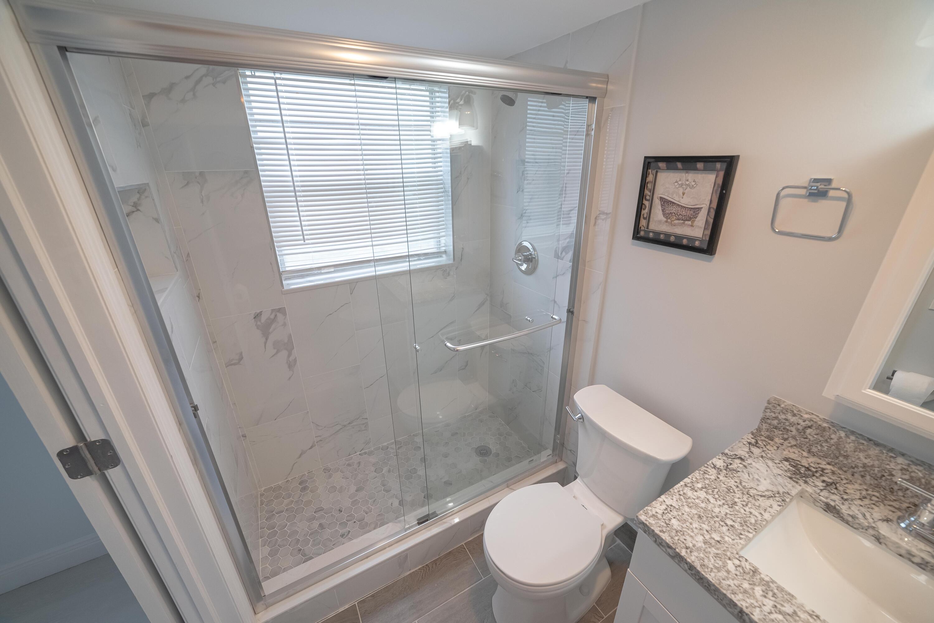 53 Lyndhurst East, Unit C Deerfield Beach, FL 33442 - Photo 20 of 23 a white toilet sitting next to a bathroom sink