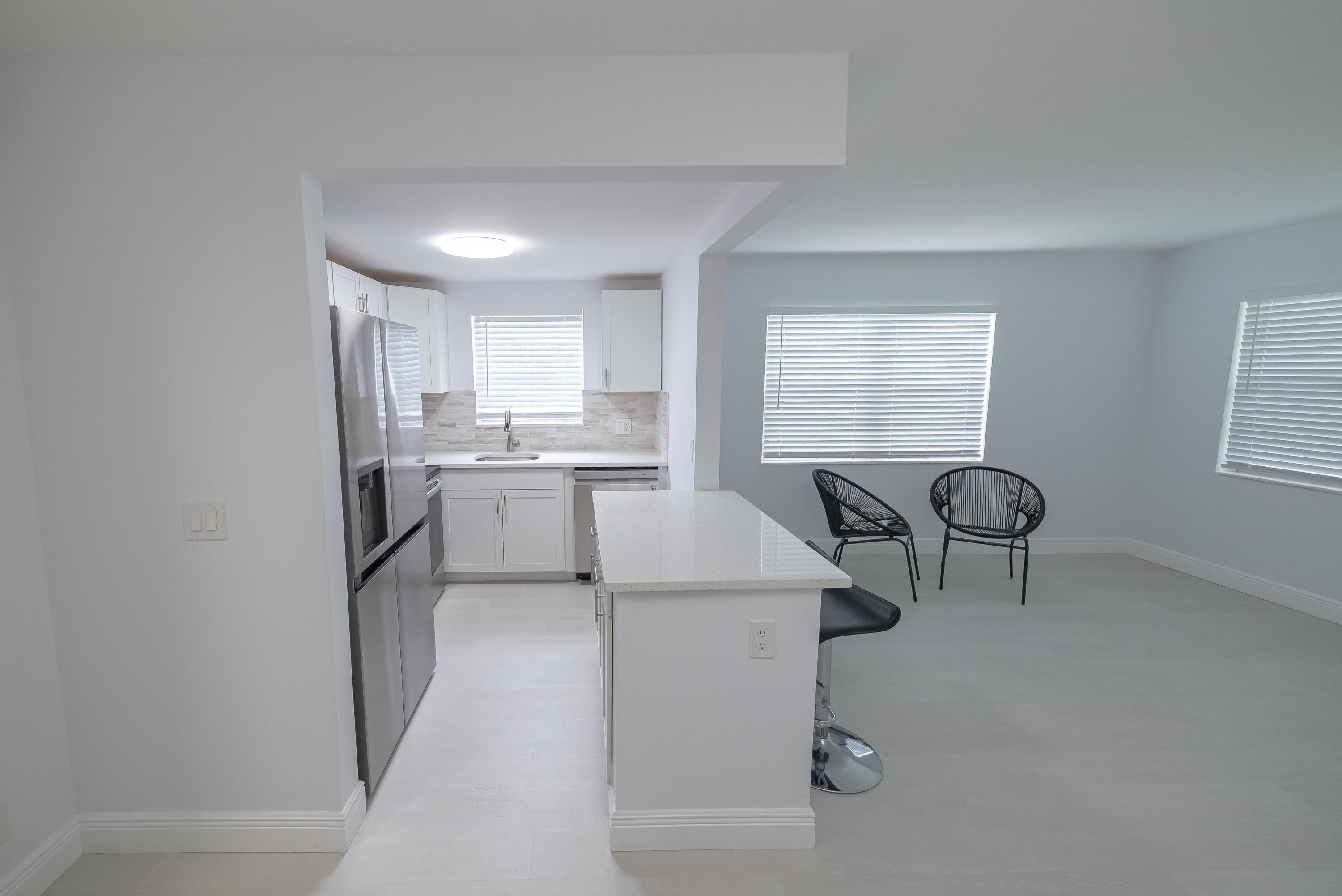 53 Lyndhurst East, Unit C Deerfield Beach, FL 33442 - Photo 2 of 23 a kitchen with a refrigerator a sink and a cabinets