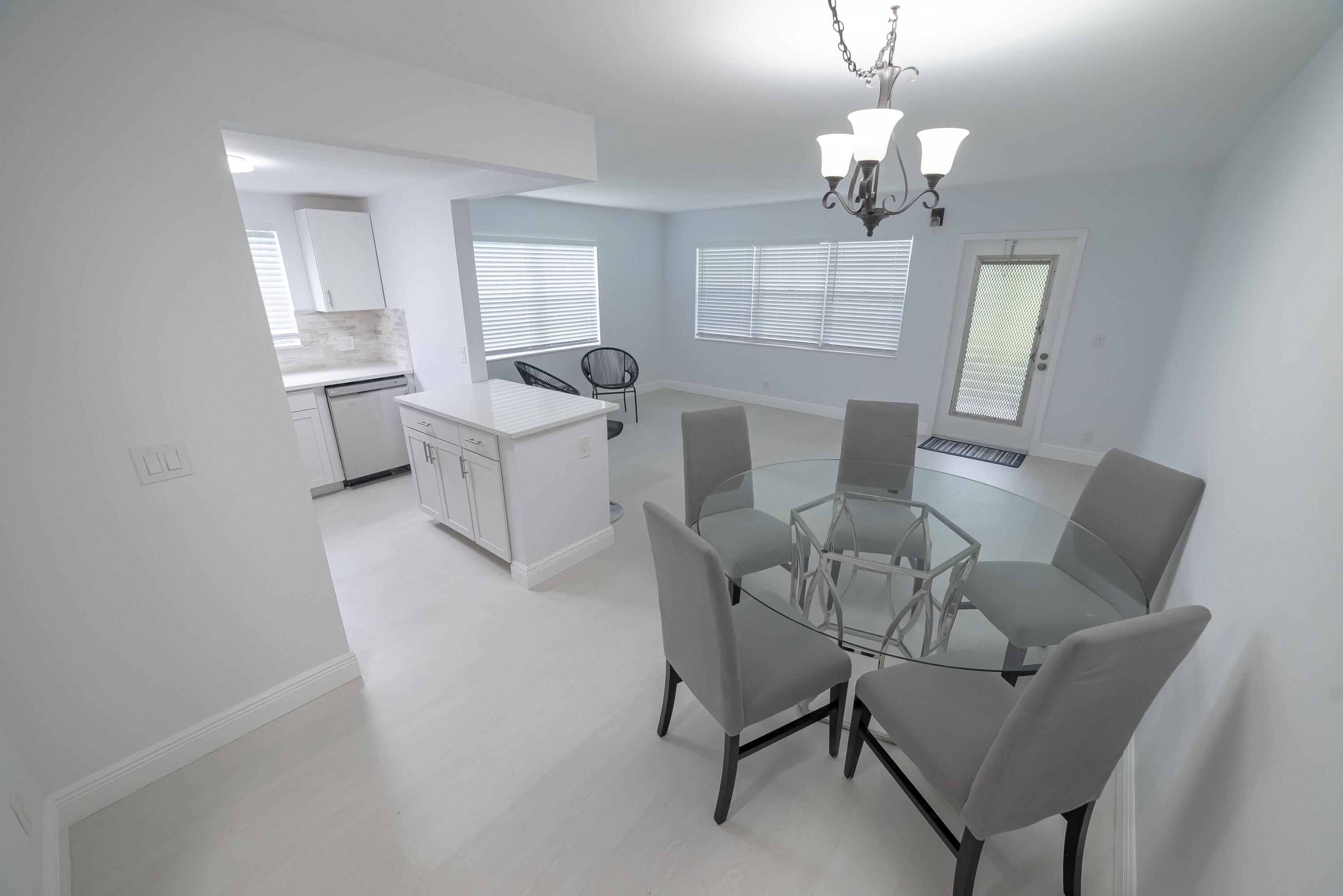 53 Lyndhurst East, Unit C Deerfield Beach, FL 33442 - Photo 3 of 23 a living room with furniture and a chandelier