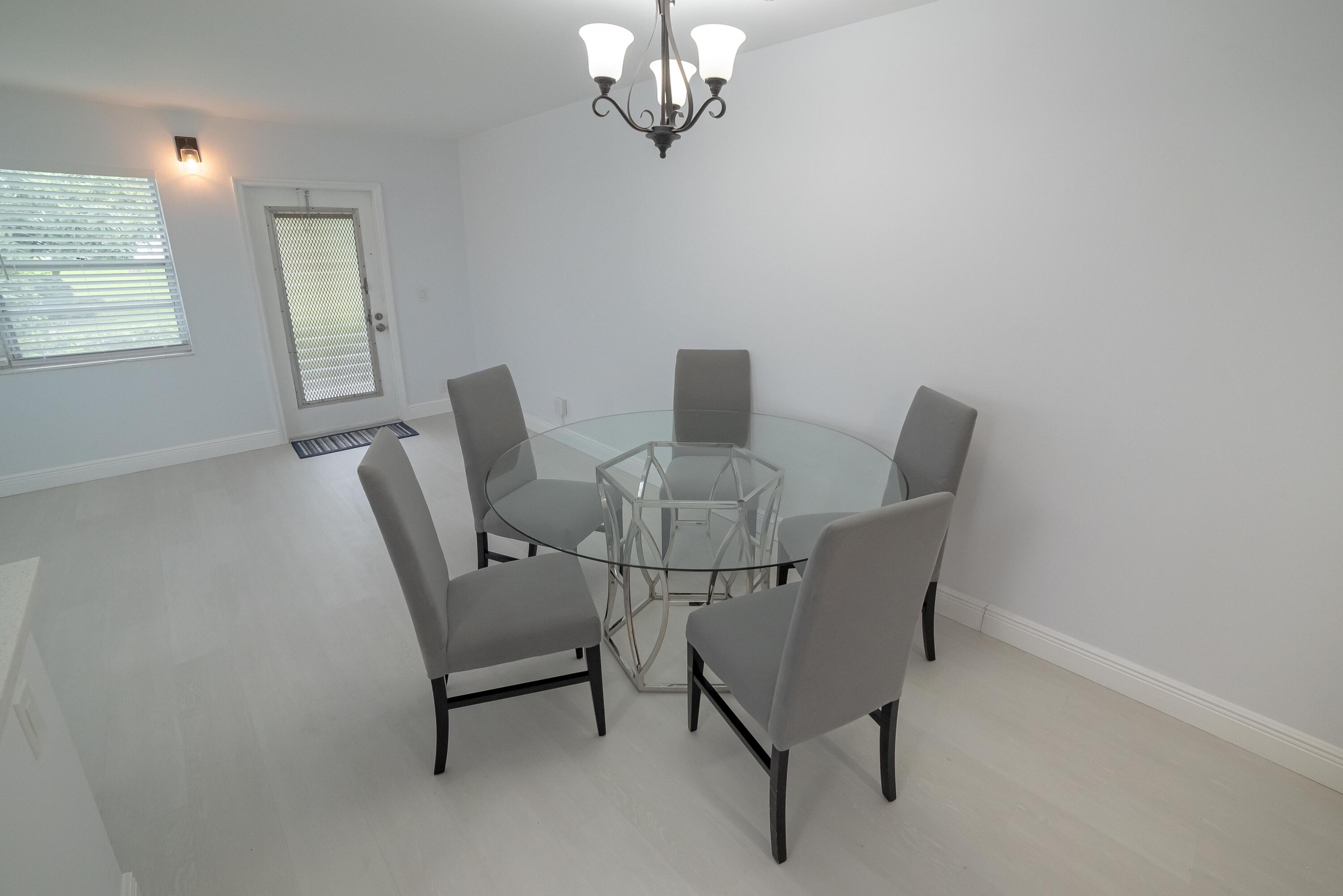 53 Lyndhurst East, Unit C Deerfield Beach, FL 33442 - Photo 6 of 23 a view of a dining room with furniture and a chandelier