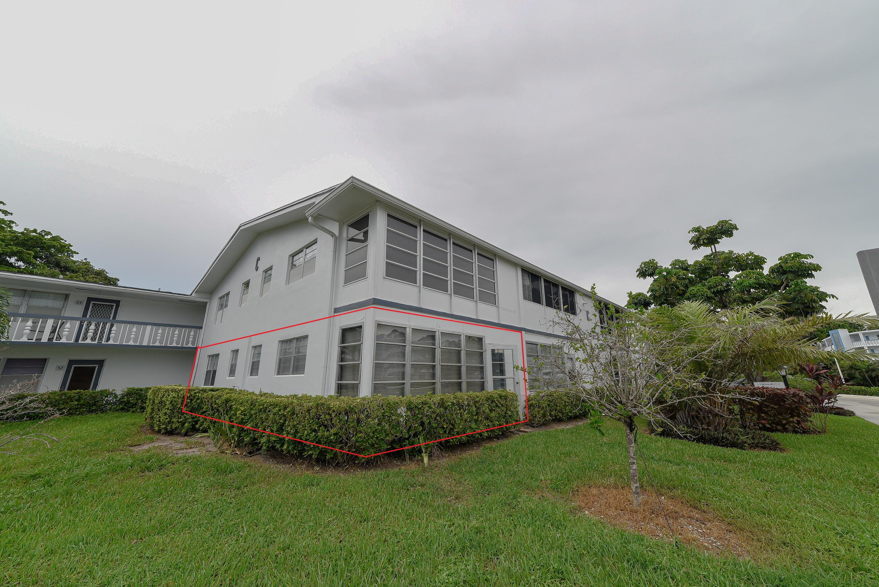 53 Lyndhurst East, Unit C Deerfield Beach, FL 33442 - Photo 10 of 23 a front view of a house with a yard