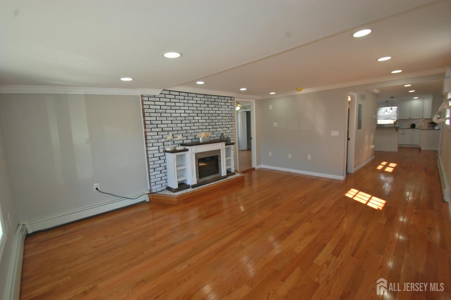 807 6th Street Union Beach, NJ 07735 - Photo 18 of 44 an empty room with wooden floor and fireplace