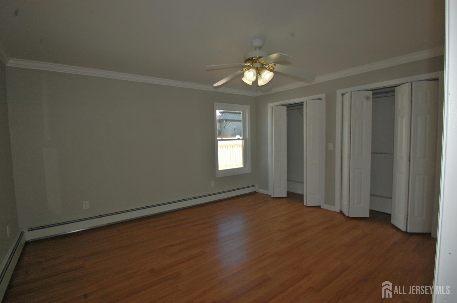 807 6th Street Union Beach, NJ 07735 - Photo 21 of 44 an empty room with wooden floor and windows