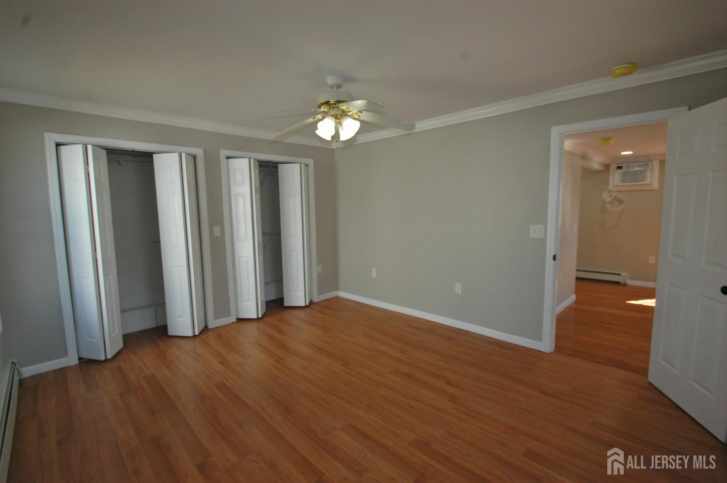 807 6th Street Union Beach, NJ 07735 - Photo 22 of 44 an empty room with wooden floor and windows