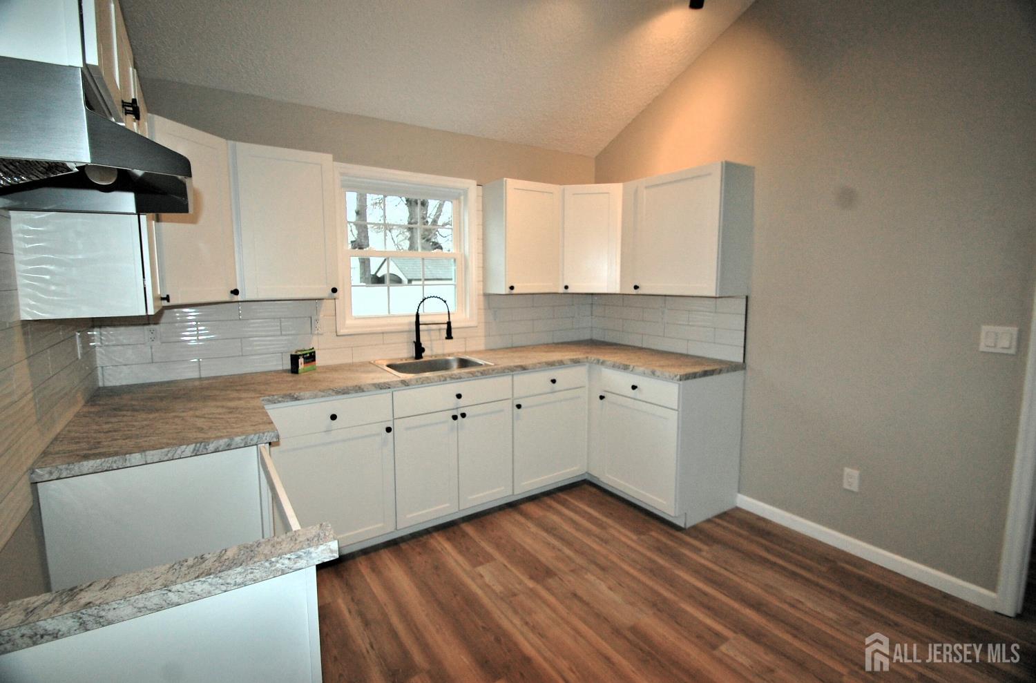 807 6th Street Union Beach, NJ 07735 - Photo 32 of 44 a kitchen with wooden floors and white appliances