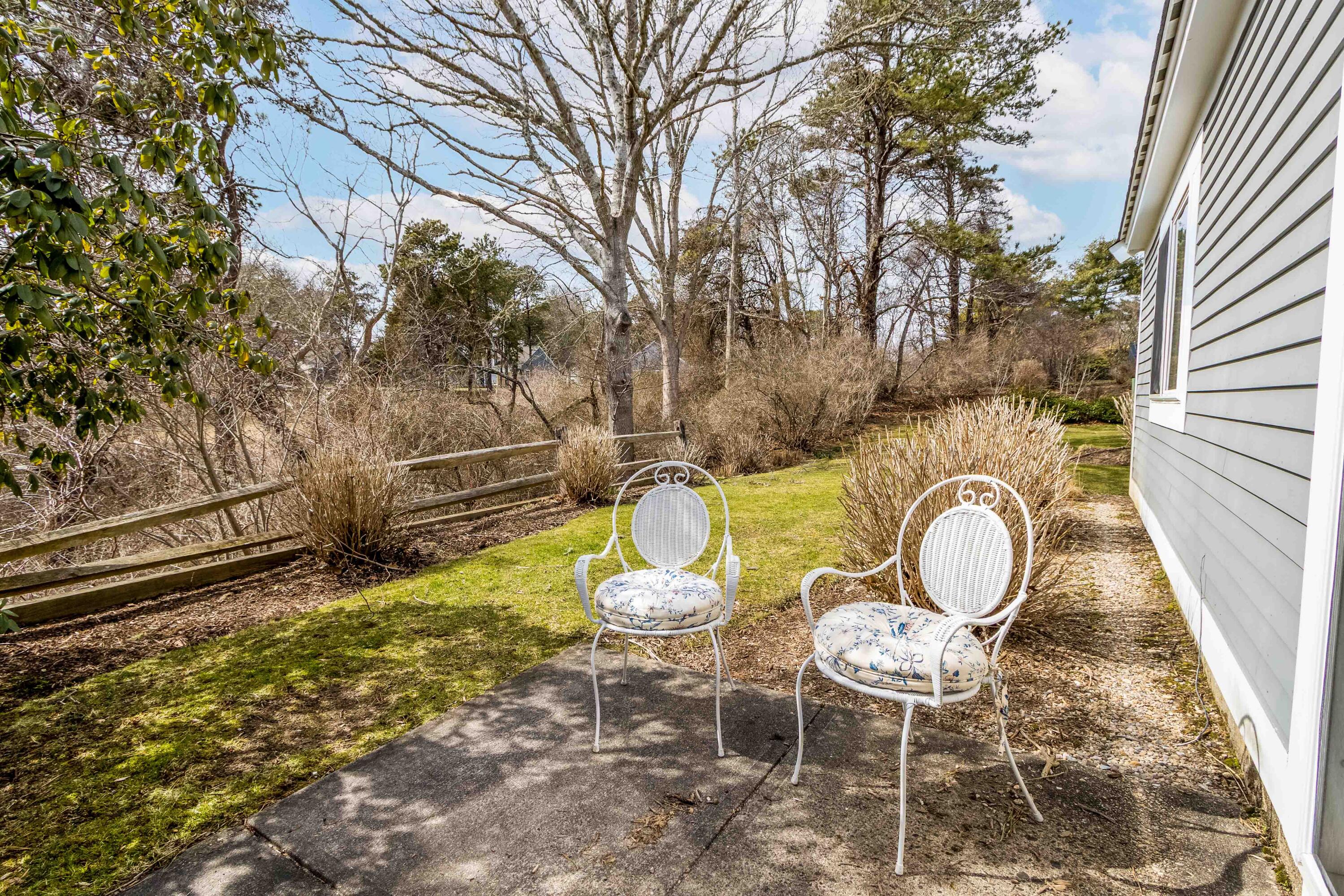 48 Middlecott Lane, Unit 48 Brewster, MA 02631 - Photo 21 of 36 a backyard of a house with table and chairs