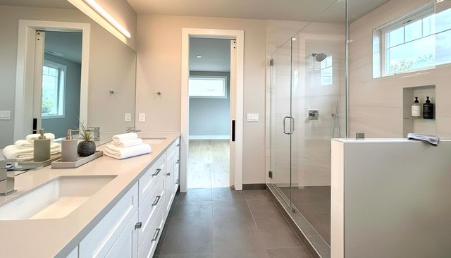 a spacious bathroom with a double vanity sink mirror and shower