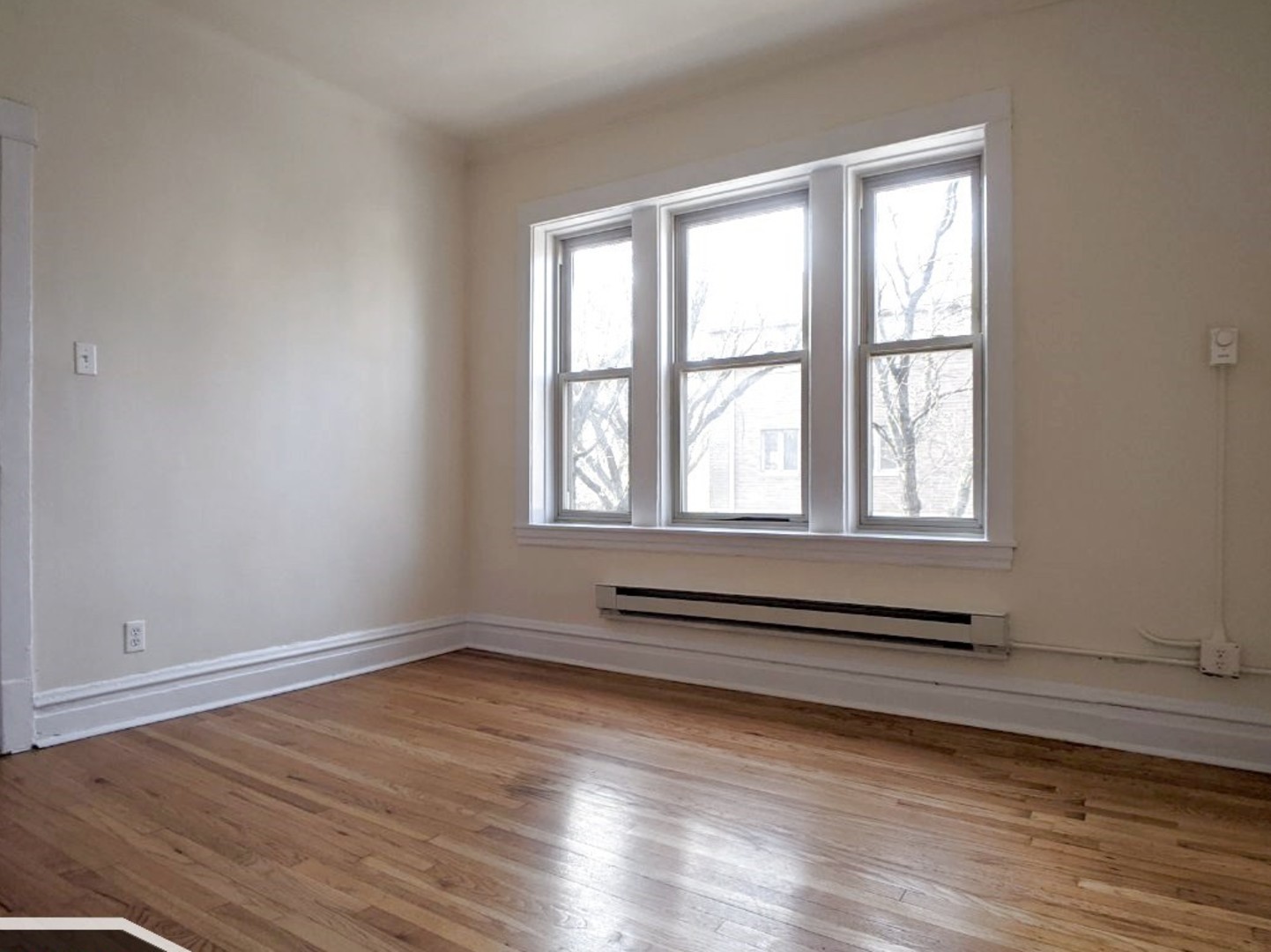 2919 West George Street, Unit 2 Chicago, IL 60618 - Photo 3 of 14 wooden floor in an empty room with a window