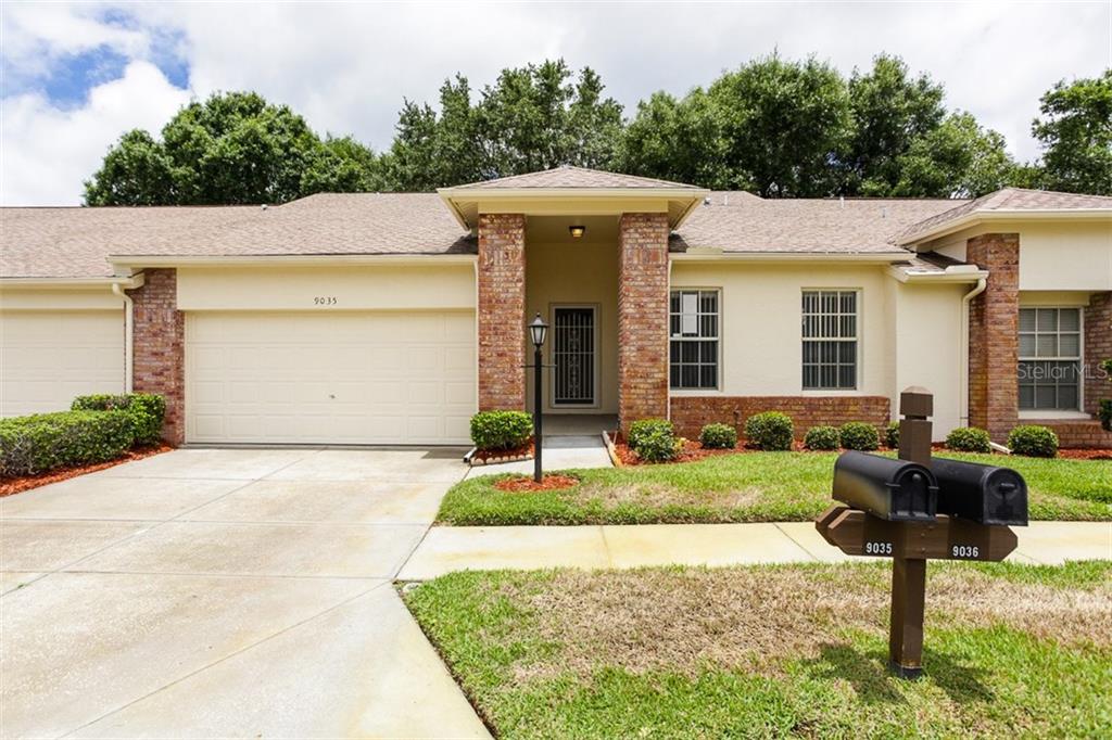 9035 Warwick Lane, Unit 1 New Port Richey, FL 34655 - Photo 1 of 1 a front view of a house with garden