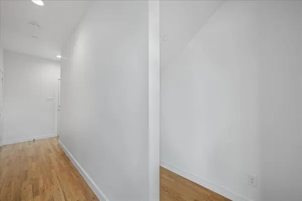 a view of a hallway with wooden floor