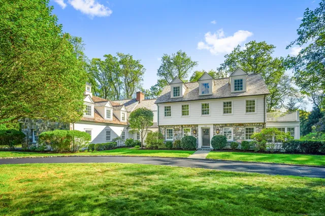 a view of a house with a big yard and large trees