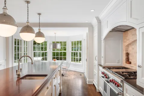 a kitchen with stainless steel appliances granite countertop a stove a sink and a wooden floors