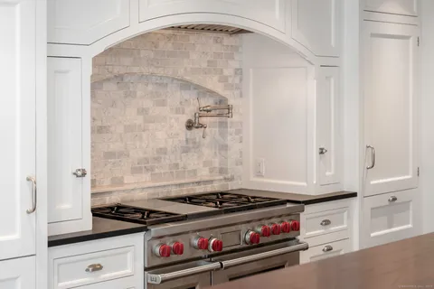 a stove top oven sitting inside of a kitchen