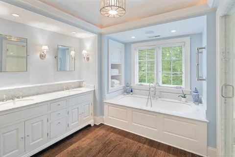 a bathroom with double vanity sinks and a mirror