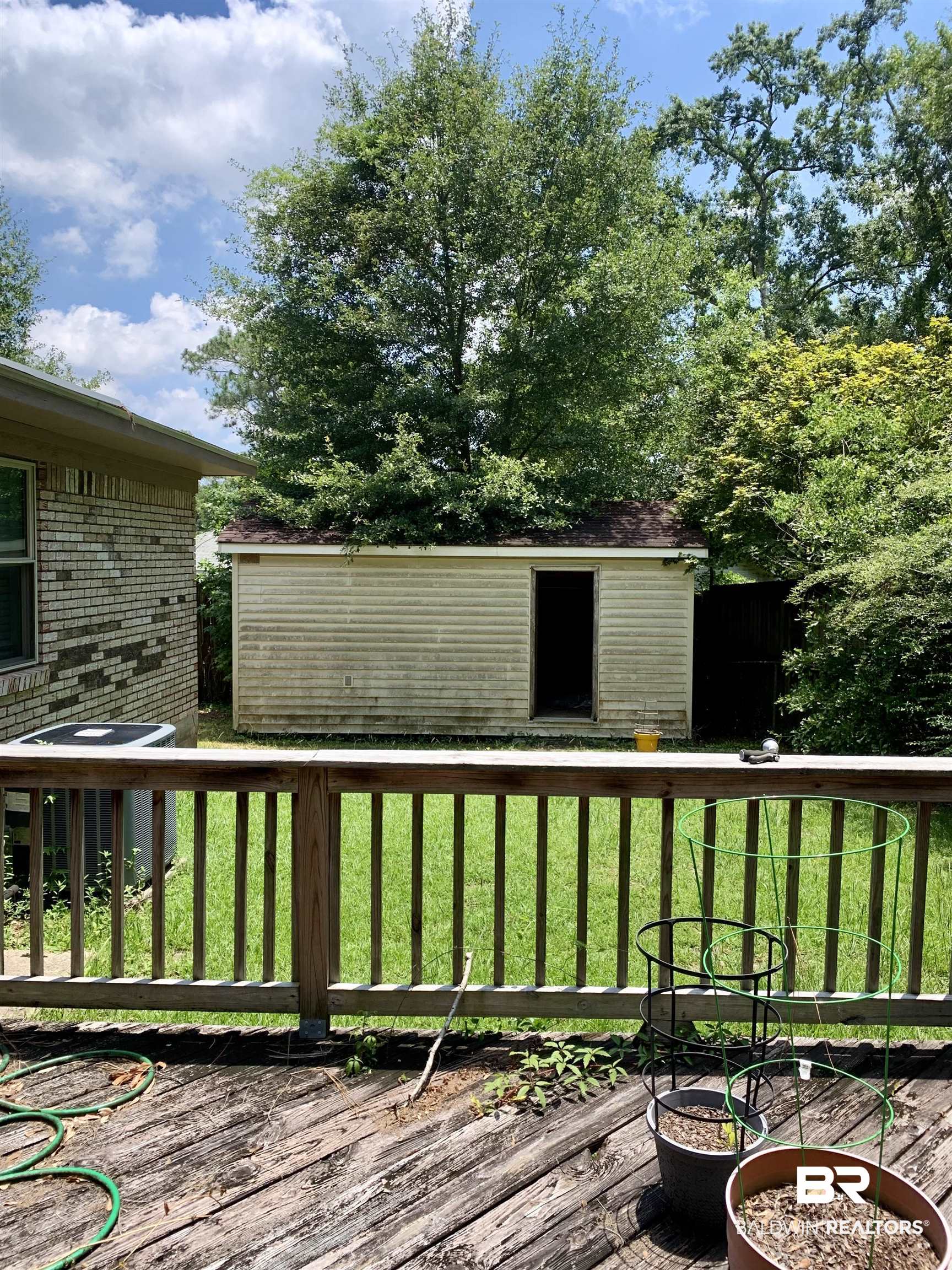 2708 E Road Mobile, AL 36693 - Photo 11 of 12 Wooden terrace with a lawn and central AC unit