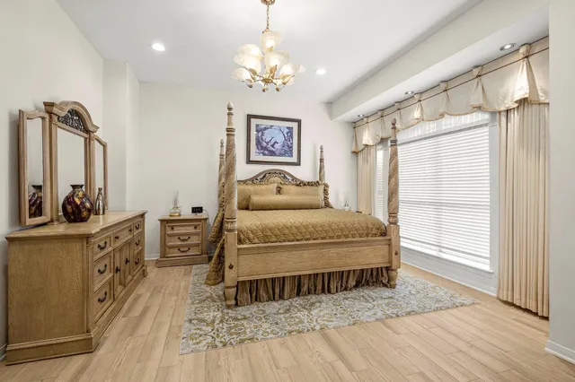 a bedroom with a bed and a mirror on the dresser