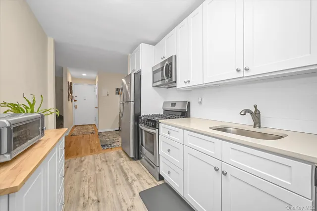 a kitchen with stainless steel appliances granite countertop a sink a stove and cabinets