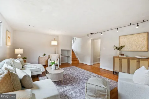 a living room with furniture and a wooden floor