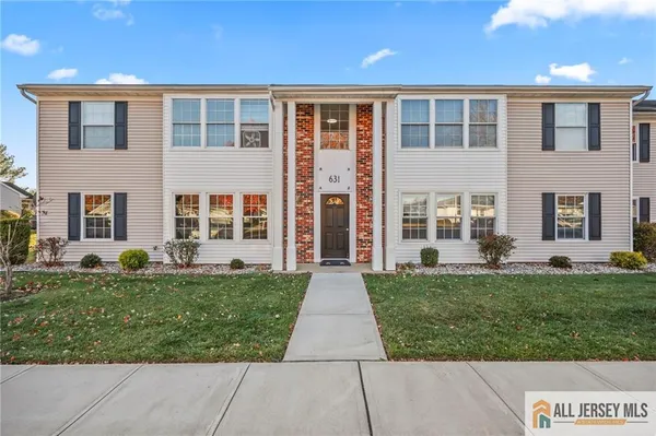 front view of a brick house with a yard
