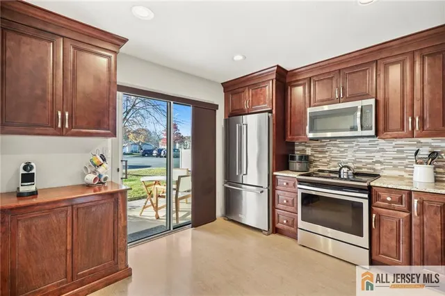 a kitchen with stainless steel appliances granite countertop a refrigerator stove and sink